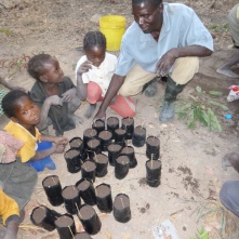 Ba Allan planting trees with some of Mfuba's younger residents.