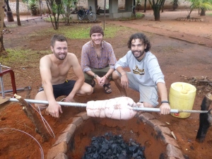 PCVs with Pig: Dan, Adam, and Zach roasting up the pig they bought, carried, and butchered for Thanksgiving.