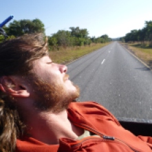 Adam enjoying the sunshine and open-air transport from the back of a pick-up truck on the Mansa Road.