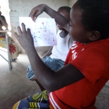 Joyci explains her drawing of her future aspirations, at an Mfuba GLOW Club meeting.