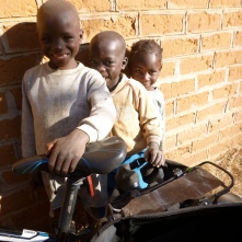 Mwango, Iggy, and Milimo convince me to take the most prized of all photos: one of them with my fancy bike.