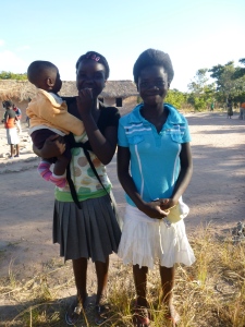 GLOW girl Muso, left, holding someones baby and standing with her friend Cynthia.