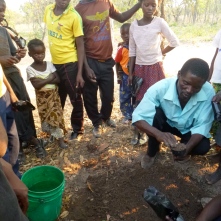 Ba Allan teaching our Grassroots Soccer HIV/gender club how to plant moringa trees.
